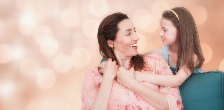 Glowing background against mother and daughter smiling at each other