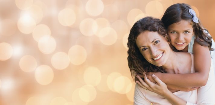 Glowing background against happy mother and daughter smiling at camera 