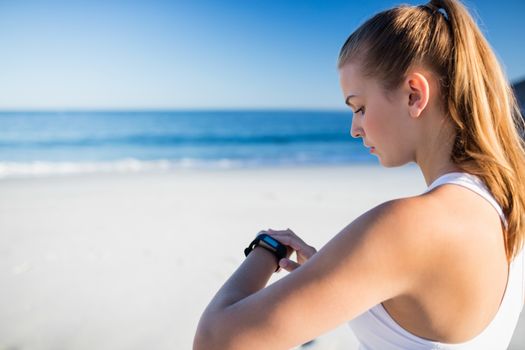 Woman using a smart watch on the beach