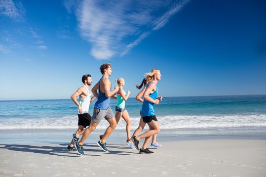 People jogging on the beach on a sunny day