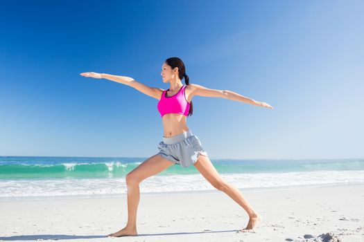Woman doing yoga on the beach on a sunny day