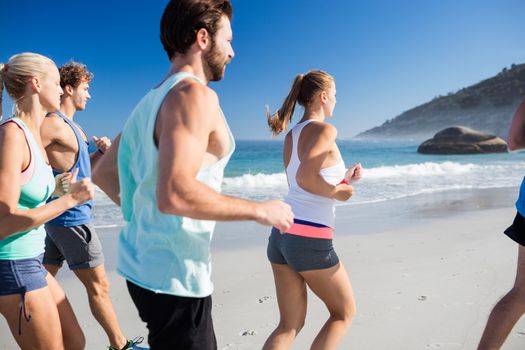 People jogging on the beach on a sunny day