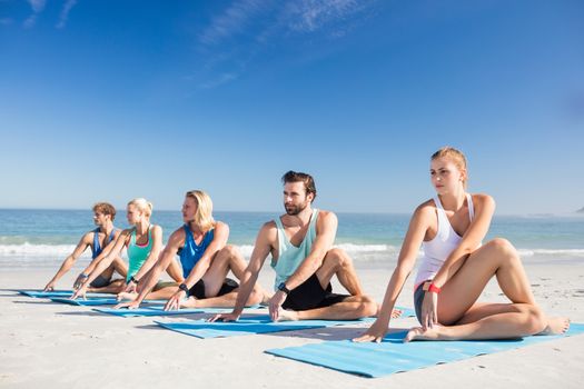 People doing yoga on the beach on a sunny day