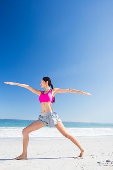 Woman doing yoga on the beach on a sunny day