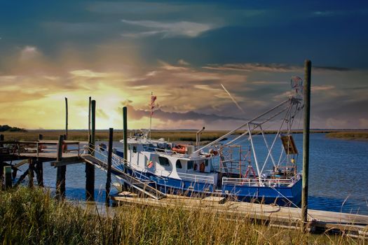 A blue and white shrimp boat at a wetlands dock