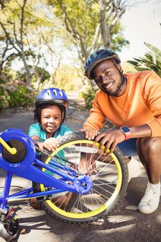 Family repairing a bike at park 