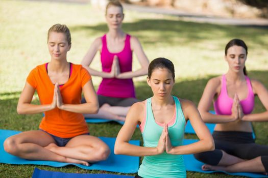 Happy women practicing yoga in park
