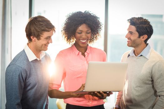 Business people discussing over laptop in office