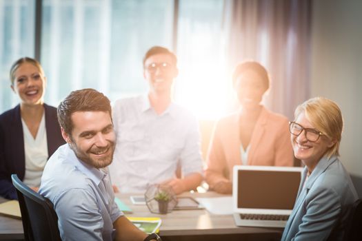 Portrait of business people sitting at desk in the office