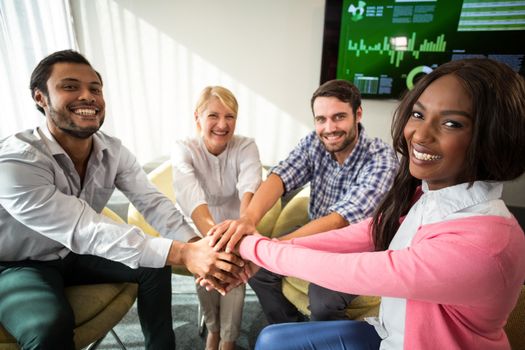 Portrait of business people with hand stacked during meeting in the office