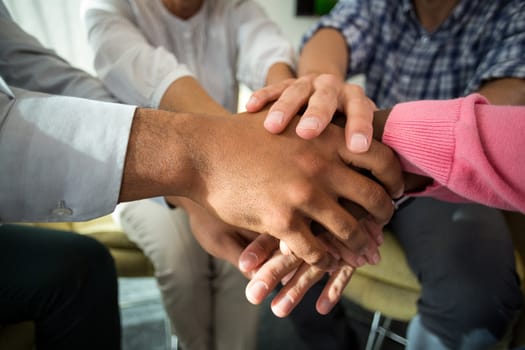 Mid section of business people with hand stacked during meeting in the office