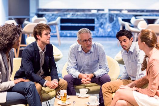 Business people sitting together and having a discussion in cafeteria