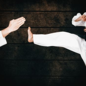 Female athlete practicing judo against dark fence