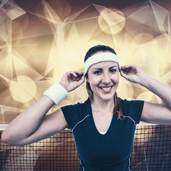 Female athlete wearing headband and wristband against lights as a background