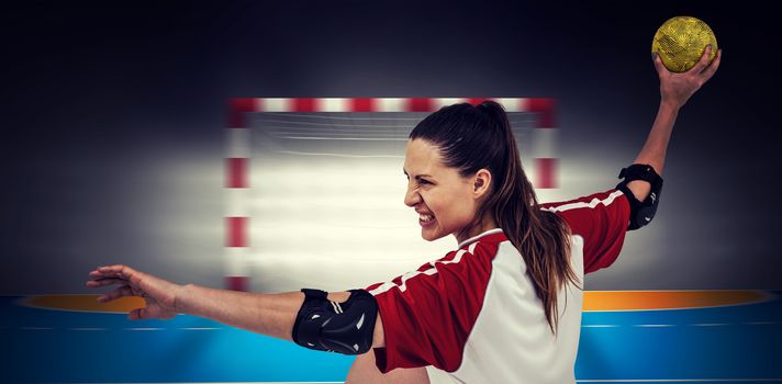 Sportswoman throwing a ball against handball field indoor 