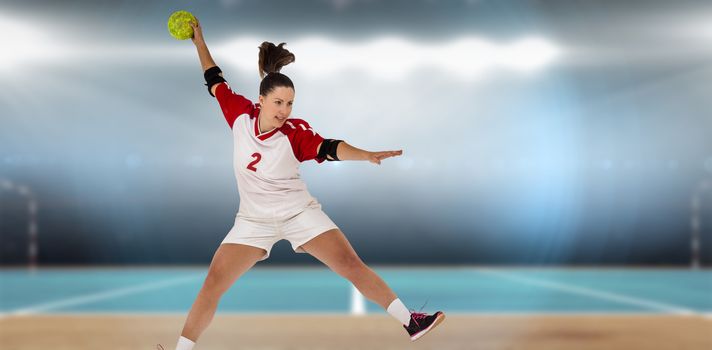 Sportswoman throwing a ball against digital image of handball field indoor