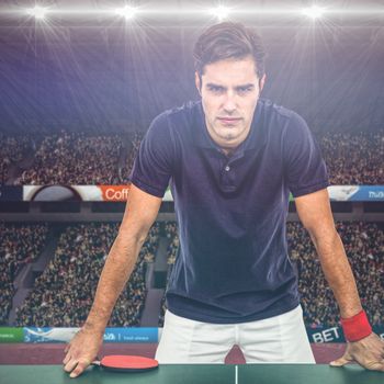 Confident male athlete leaning on hard table against view of a stadium