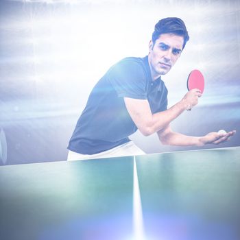 Confident male athlete playing table tennis against american football arena