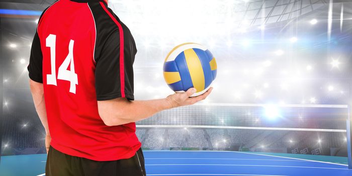 Sportsman holding a volleyball against view of a volleyball field