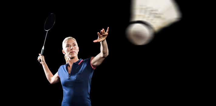 Badminton player playing badminton on black background