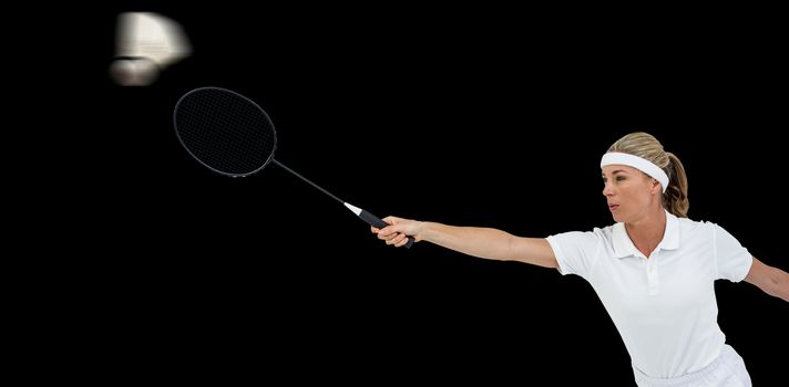 Female athlete playing badminton on black background