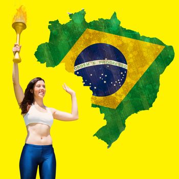 Front view of sportswoman raising a cup against green brazil outline with flag on yellow