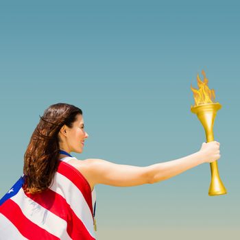 Rear view of american sportswoman holding a cup  against blue sky