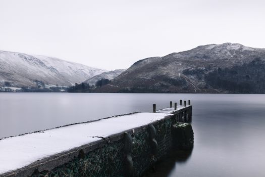 The winter scene includes a landing stage on the banks of Ullswater, Cumbria in the English Lake District.