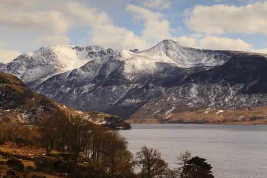 A view across Crummock Water towards the snow capped lakeland fells in the English Lake District national park.