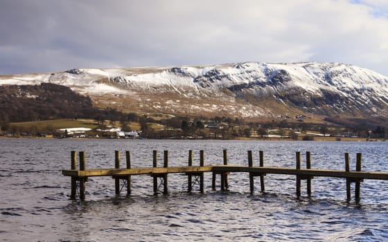 A winter view across Ullswater to the snow capped hills in the English Lake District National Park.