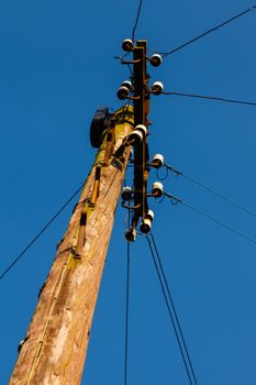 A wooden electricity pylon with cables.