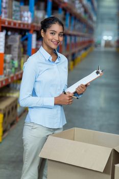 Portrait of happy manager is posing and smiling during work in a warehouse