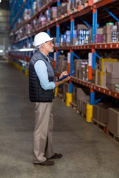 Portrait of manager is working with a clipboard in a warehouse