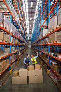 View of managers are looking up and pointing shelves in warehouse