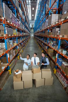 High angle view of managers are looking up and pointing shelves in a warehouse