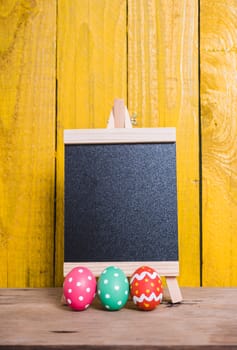 Easter eggs on wooden yellow background and have work space for use