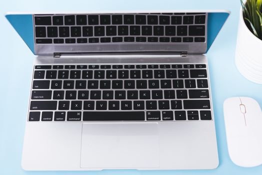 Top view of modern technology smart phone mobile and computer laptop on blue background with copy space
