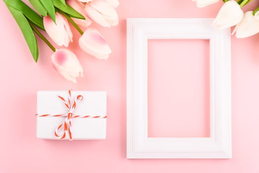 Happy Women's Day, Mother's Day concept. top view flat lay Tulip flower and photo frame on pink background, copy space for your text