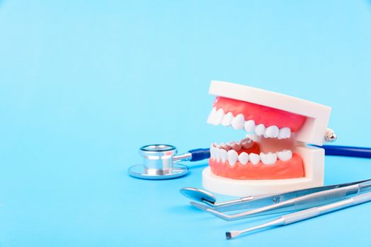 Dental Hygiene Health Concept, White tooth and Dentist tools for dental care on blue background