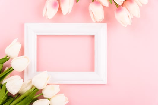 Happy Women's Day, Mother's Day concept. top view flat lay Tulip flower and photo frame on pink background, copy space for your text