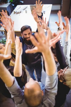 High angle view of creative business people cheering in office