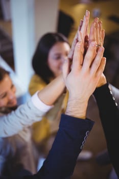 High angle view creative business people high fiving at office