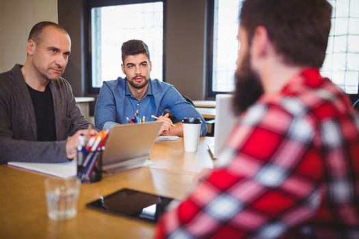 Business people discussing at desk in creative office