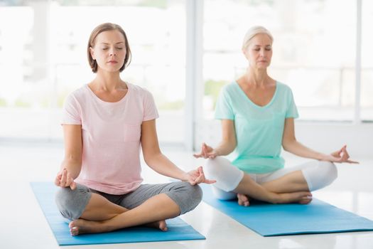 Full length of women in lotus position doing yoga