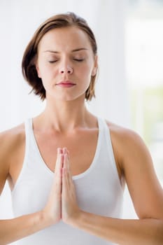 Young woman perfroming yoga at fitness studio