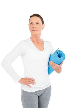 Mature woman holding exercise mat while standing on white background