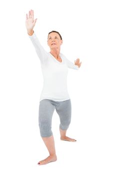 Mature woman with arms outstretched while exercising on white background