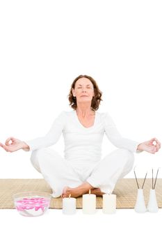 Full length of mature woman meditating against white background