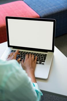 Cropped image of woman using laptop in library