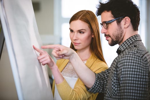 Smart business people pointing on whiteboard in meeting room